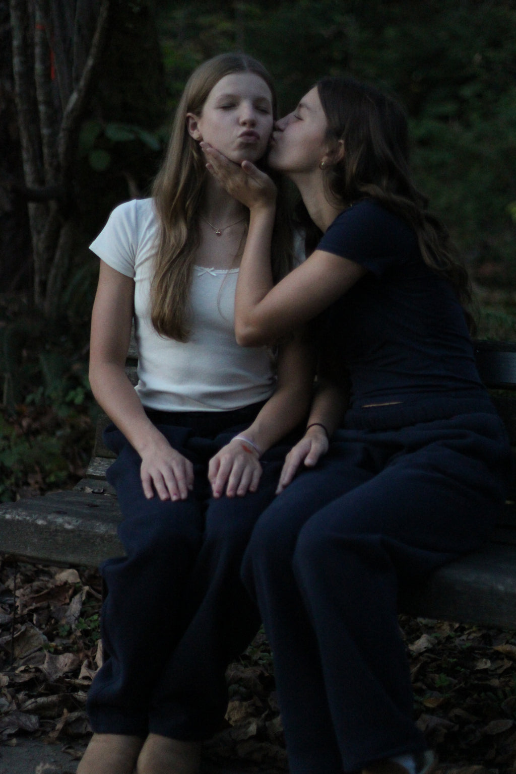 Two people lying on the ground in a forest setting