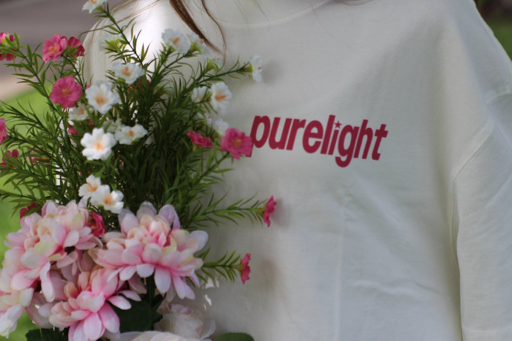 White shirt with 'purelight' text next to a bouquet of flowers