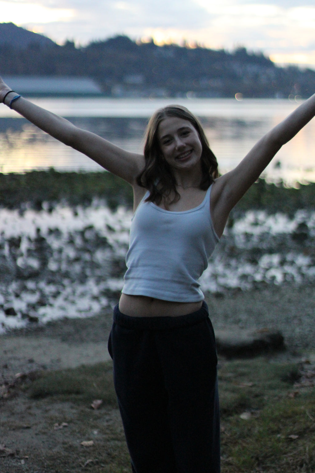 Person standing with arms outstretched in a natural setting